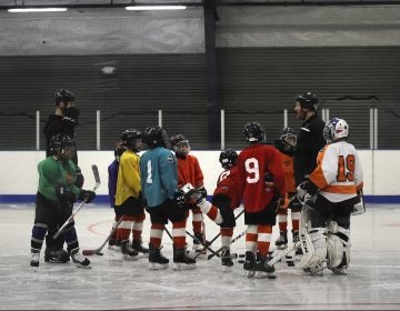 FILE - In this Feb. 21, 2019, file photo, Malakye Johnson (1) gathers with his teammates during a Snider Hockey practice at the Scanlon Ice Rink in Philadelphia. The Philadelphia-based Snider Hockey organization named after the late Flyers owner now has over 3,000 kids in its program and almost a third are girls. Snider Hockey officials want to get to a point that boys and girls are split 50-50, and a new endeavor with the Howe Foundation is another step toward that goal. (AP Photo/Matt Rourke, File)