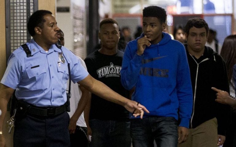 A security officer monitors students as they transition between classes during the first day of school at South Philadelphia High School Monday, Sept. 9, 2013, in Philadelphia. About 190,000 students are going back to class Monday in Philadelphia, where parents say severe staffing cuts have created an aura of uncertainty around the new academic year. Officials contend the school district is prepared despite the major budget reductions. (Matt Rourke/AP Photo)