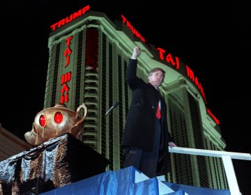 Donald Trump ascends the stairs with his fist raised from the genie's lamp after opening the Trump Taj Mahal Casino Resort in a spectacular show of fireworks and laser lights Thursday evening in Atlantic City, N.J., on April 5, 1990.  Behind Trump is the 42-story hotel.  (AP Photo/Chaarles Rex Arbogast)