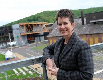 ArtsQuest President and CEO Kassie Hilgert stands on the SteelStacks campus, which sits at the base of the former blast furnaces of Bethlehem Steel. (Matt Smith for Keystone Crossroads)