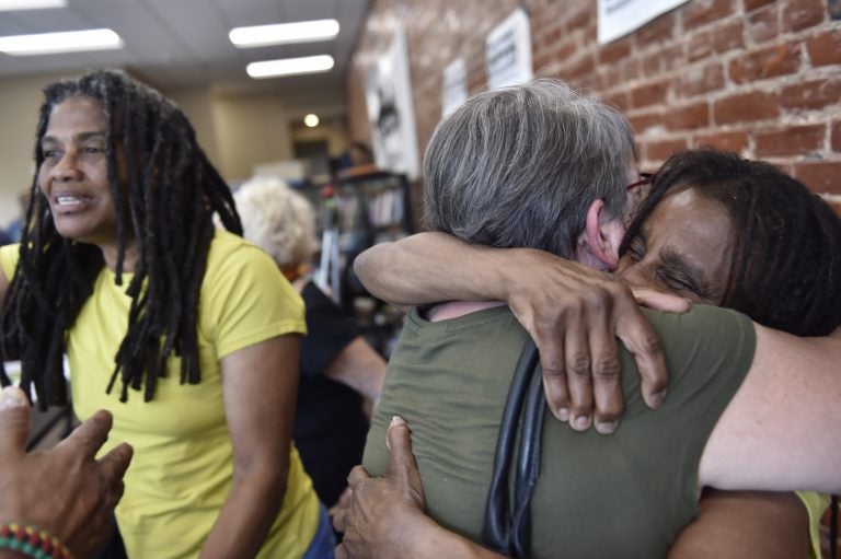 Janet Africa (right) embraces Betsy Piet while on the left, Janine Africa greets a well wisher. Janet and Janine Africa were recently released after serving 40 years in prison for their role in the shooting death of a police officer. (Jonathan Wilson for WHYY)