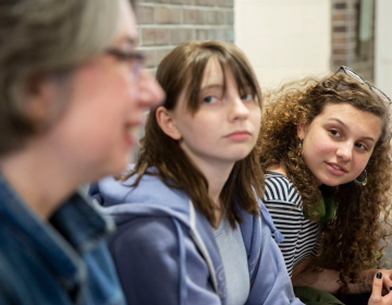 Sasha Mannino (center) and Iris Peron-Ames (right), both 15, look on as Kathryn Gay speaks with them Greenfield Elementary School on Tuesday. Graduates of Greenfield, Mannino and Peron-Ames now attend Science Leadership Academy and are running their second campaign to collect tampons and other toiletries for young people in need. (Heather Khalifa/The Philadelphia Inquirer)