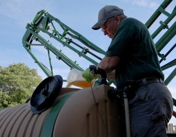 John Draper pours glyphosate into the tank of his sprayer at the University of Maryland's Wye Research and Education Center. (Dan Charles/NPR)