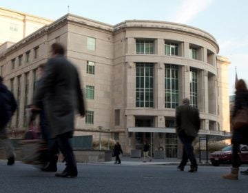 People walk by the Pennsylvania Judicial Center at the state Capitol in Harrisburg.