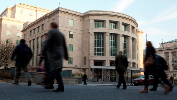 People walk by the Pennsylvania Judicial Center at the state Capitol in Harrisburg.