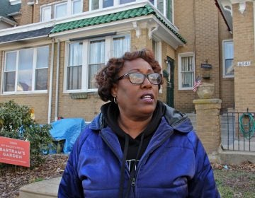 Tracey Gordon stands in front of homes in her Southwest Philadelphia neighborhood. (Emma Lee/WHYY)