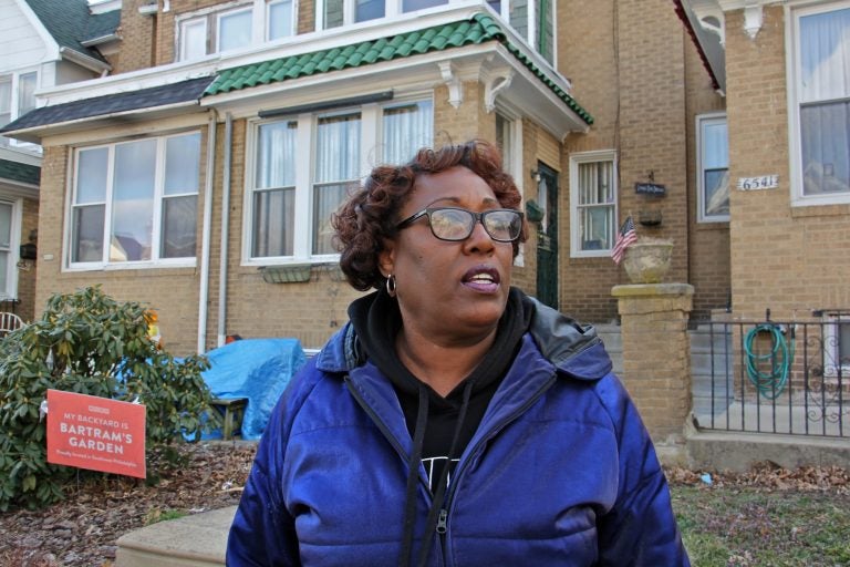 Tracey Gordon stands in front of homes in her Southwest Philadelphia neighborhood. (Emma Lee/WHYY)