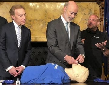 Gov. Tom Wolf listens to trainer Elvis Rosado, (right), of Philadelphia-based Prevention Point on how to administer a nasal spray that reverses an opioid overdose during a demonstration in Wolf's Capitol offices, Wednesday, May 22, 2019, in Harrisburg, Pa. Looking on is Paul Tufano, CEO of AmeriHealth Caritas, a Medicaid insurer that sponsors training. (Marc Levy/AP Photo)