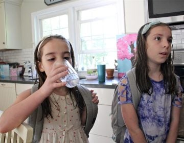 Emily Cutaiar, 8,  (left) and her sister Jessica, 9, know not to drink water from the tap in their Sellersville home. Their well was found to be contaminated with PFAS. (Emma Lee/WHYY)