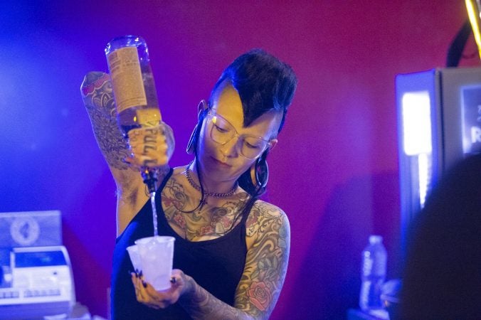 Luna Dahlia mixes drinks behind the bar prior to the last performance at the Troc. (Jonathan Wilson for WHYY)