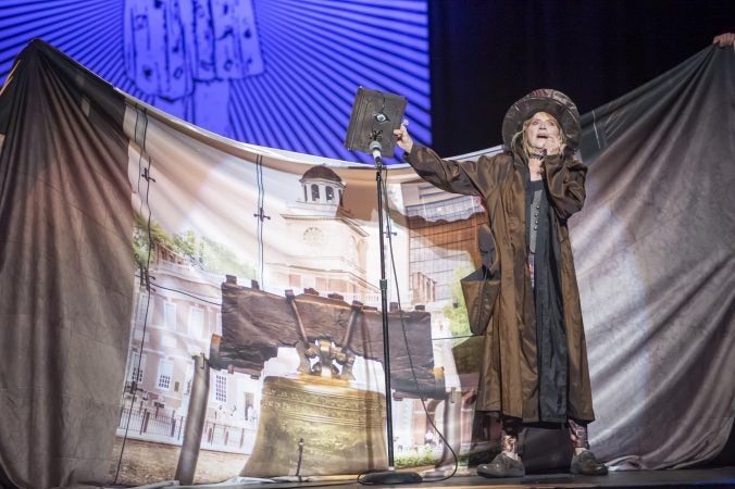 VertigoPlanes artist Mauri Walton holds the Book of Spells aloft. (Jonathan Wilson for WHYY)