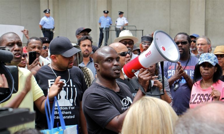 Columnist and commentator Solomon Jones leads a rally at Philadelphia police headquarters to call for action against police officers who posted racist comments on Facebook. (Emma Lee/WHYY)