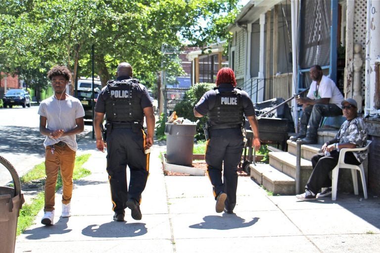 Trenton police officers patrol on foot on Walnut Street, where one person was killed and five injured in a mass shooting on May 28. (Emma Lee/WHYY)