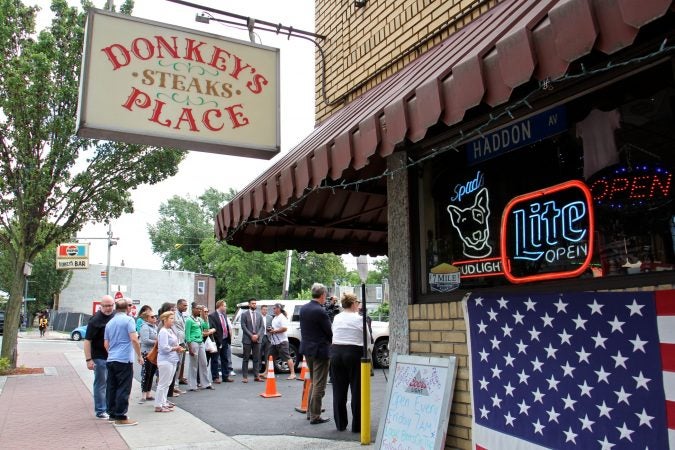 A small crowd gathers outside Donkey's Place in Camden for the announcement of the Anthony Bourdain Food Trail. (Emma Lee/WHYY)