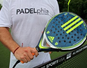 A padel racquet is a lightweight paddle strengthened with carbon and shot through with holes. Racquets like this one cost from $80 to $140. (Emma lee/WHYY)