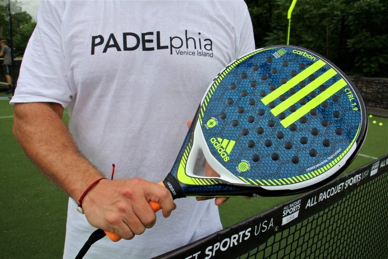 A padel racquet is a lightweight paddle strengthened with carbon and shot through with holes. Racquets like this one cost from $80 to $140. (Emma lee/WHYY)