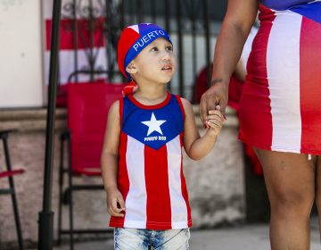 Jashua Vargas from Camden takes part in the San Juan Bautista Parade and Festival on the Camden waterfront. The parade has been a tradition in the city for the 62 years. (Miguel Martinez/WHYY)