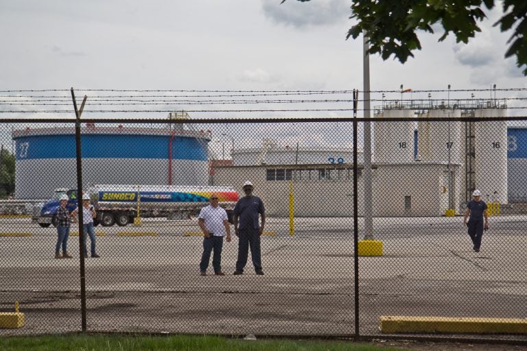 Refinery works watch protestors outside the PES refinery Tuesday. (Kimberly Paynter/WHYY)