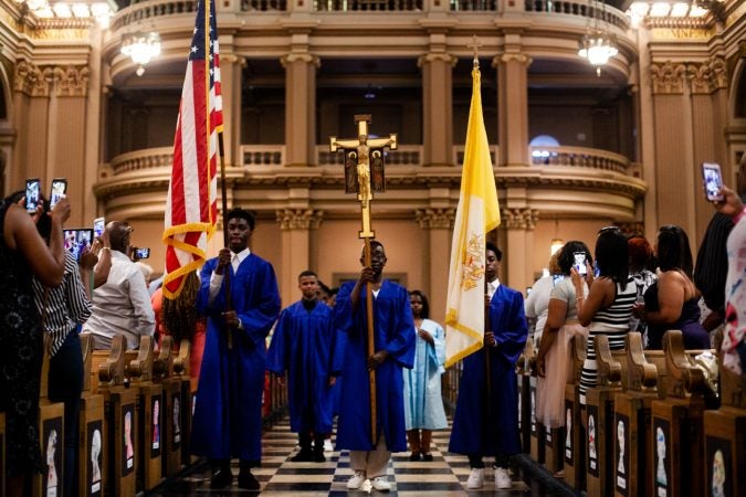 Students walk in lockstep inside the Church of the Gesu before the school's graduation ceremony earlier this month. (Brad Larrison for WHYY)