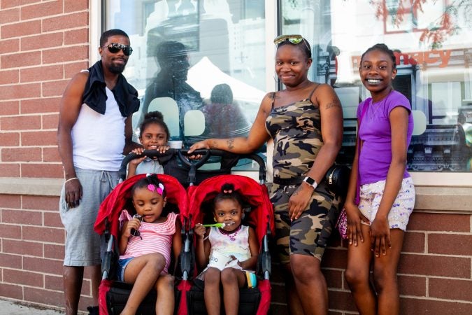 Lakeea and Brandon Taylor are pictured  with their children on South Street during the annual Odunde Festival Sunday. (Brad Larrison for WHYY)