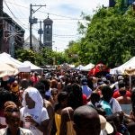 People walk on a street during a street festival.