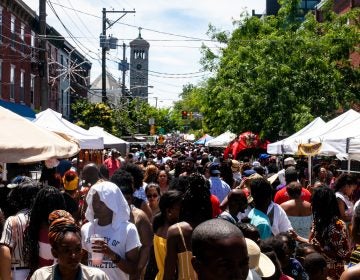 People walk on a street during a street festival.