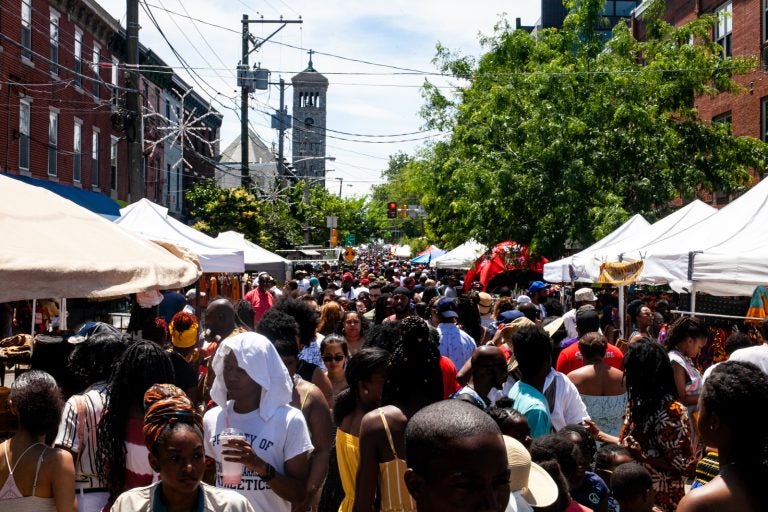 People walk on a street during a street festival.