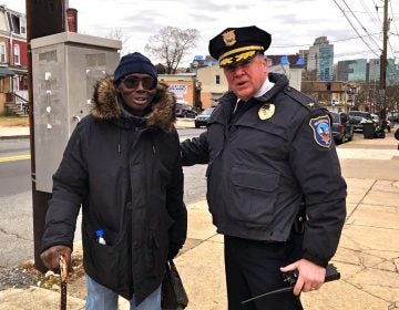 Wilmington Police Chief Robert J. Tracy with resident Robert Flonnory on Market Street. Tracy has been credited with bringing down the crime rate in the city by building bridges within communities. (Cris Barrish/WHYY)