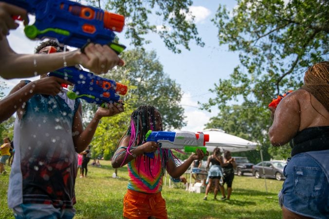 Amani Hutcherson sprays a water gun during the Water Fight Philly event on Sunday, June 30, 2019. (Kriston Jae Bethel for WHYY)