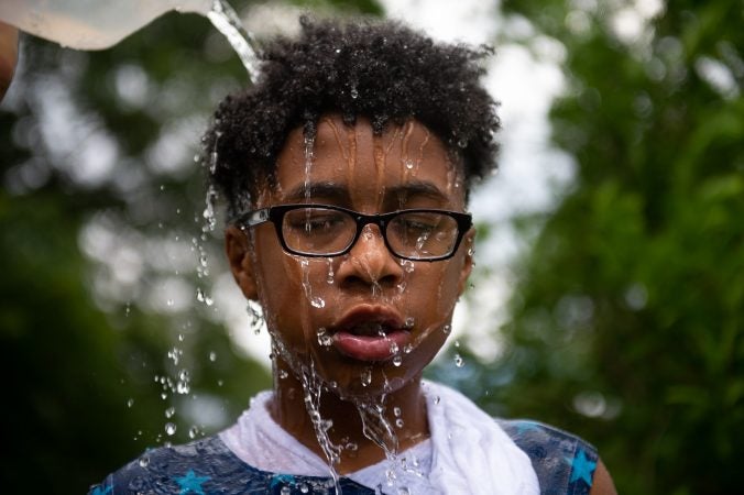 Luis Rentals has water dumped on his head during the Water Fight Philly event on Sunday, June 30, 2019. (Kriston Jae Bethel for WHYY)