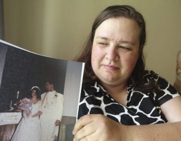 Heidi Clark holds a photograph from her 1995 wedding at her home in Orem, Utah, on Friday, May 18, 2018. Clark became pregnant at 16 and married soon after, under pressure from her boyfriend's religious community of Seventh-Day Adventists in Pennsylvania, she said. “I always felt a little bit like I was trapped,” Clark said, now 40. “I was 17. I was so young.” (Rick Bowmer/AP Photo)