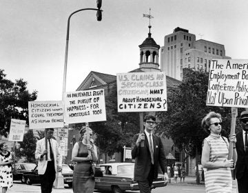 FILE - In this July 4, 1967 file photo Kay Tobin Lahusen, right, and other demonstrators carry signs calling for protection of homosexuals from discrimination as they march in a picket line in front of Independence Hall in Philadelphia. In 2019, same-sex marriage is the law of the land in the U.S. and at least 25 other countries. LGBT Americans serve as governors, big-city mayors and members of Congress, and one _ Pete Buttigieg _ is waging a spirited campaign for president. (AP Photo/John F. Urwiller)