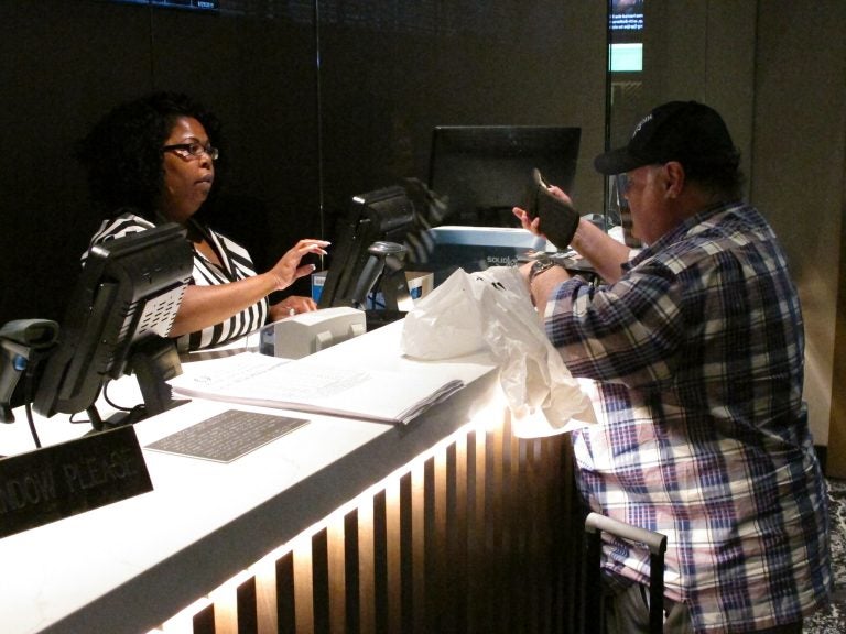 In this June 27, 2019 photo, a clerk takes a bet from a gambler at the new sportsbook at Bally's casino in Atlantic City, N.J. New Jersey surpassed Nevada in terms of sports betting volume in May, taking the national lead for the first time. (AP Photo/Wayne Parry)