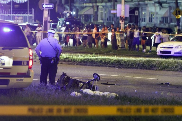 A police officer stands by a sheet covering the remains of a young child and a baby stroller at the scene of a fatal accident on Roosevelt Boulevard in the Olney section of Philadelphia on Tuesday July 16, 2013. (Joseph Kaczmarek/AP Photo)