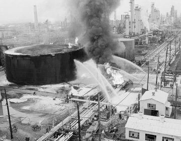 Fireman direct water at a crude oil storage tank and oil lines that exploded at the Gulf Oil Refinery in Philadelphia, Sunday, August 17, 1975. Main route and bridge over the refinery were closed to the Philadelphia international airport. (Rusty Kennedy/AP Photo)