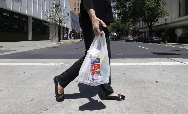 A woman walks with a plastic bag