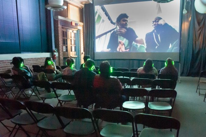 Art All Night featured a film festival. 200 short films were selected from 3,000 international submissions and were played continuously throughout the event. Here the audience listens on headphones to cancel out the festival's ambient noise. (Jonathan Wilson for WHYY)