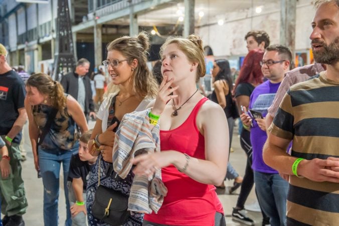 Amanda Ellen, left, Samantha Bernstein, and Aaron Moskovitz admire some of the artwork on display. (Jonathan Wilson for WHYY)