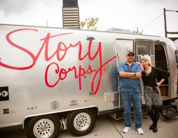 WHYY engineer, Al Banks, left, and WHYY's Morning Edition host, Jennifer Lynn, pose outside the StoryCorps MobileBooth which is parked this month at The Porch at 30th Street Station.  (Laurie Beck Peterson)

