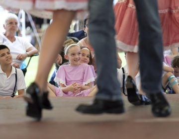 Jayda Rutherford (center) watches as older family members perform in the Miller Family Hoedown on July 1, 2018, during the Kutztown Folk Festival in Kutztown, Pennsylvania. (Matt Smith for WHYY)