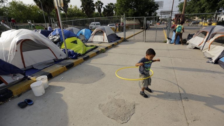 William Linares, a 5-year-old from Honduras, plays in an encampment where he is living near the international bridge in Matamoros, Mexico, on April 30. The boy is traveling with his mother, Suanny Gomez, and seeking asylum in the United States. (Eric Gay/AP Photo)