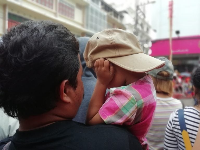 Child wear hat closing his ears for fear loud noise