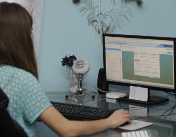 Celiah Aker works on her business and administrative services class at her desk at home (AP Photo/Tony Dejak)