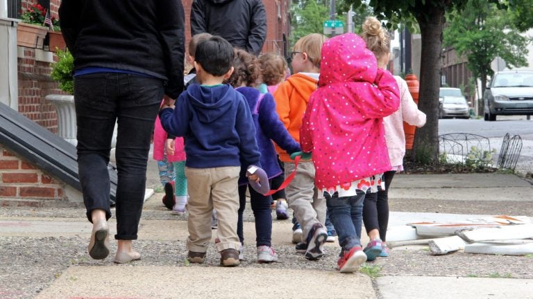 A group of children walk with their caregivers on Vine Street.  (Emma Lee/WHYY)