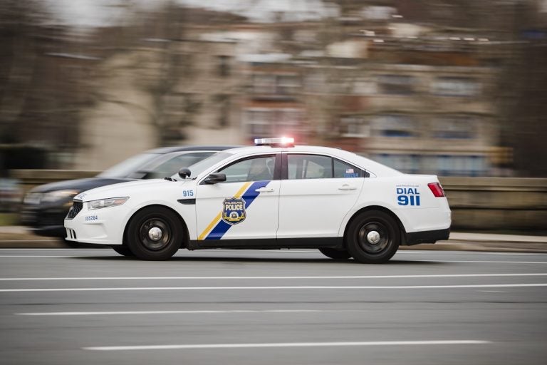 A police car drives with its lights flashing in Philadelphia.