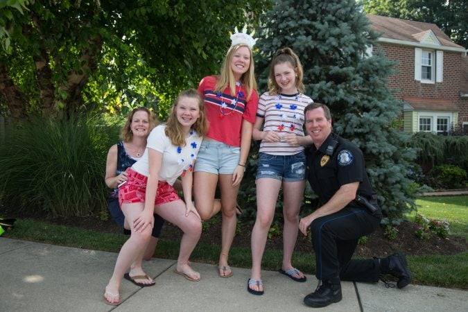 The Sharkey Family recreates a photo taken of the family in 2006. They have been coming to the Marple Newtown Fourth of July parade since their eldest, Bridget, 18 (middle), was born. (Emily Cohen for WHYY)