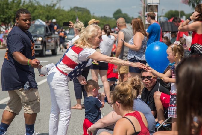 Pa. Congresswoman Mary Gay Scanlon hands out candy and shakes hands with community members along the route of the annual Marple Newtown Fourth of July parade. (Emily Cohen for WHYY)