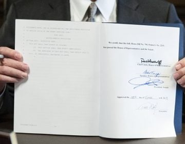 Governor Tom Wolf holding up the signed 2019-20 budget. The Commonwealth Foundation says it contains $61 million in earmarks. (Matt Rourke/AP Photo)