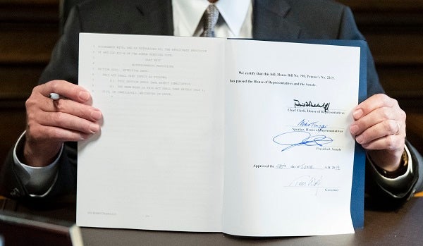 Governor Tom Wolf holding up the signed 2019-20 budget. The Commonwealth Foundation says it contains $61 million in earmarks. (Matt Rourke/AP Photo)