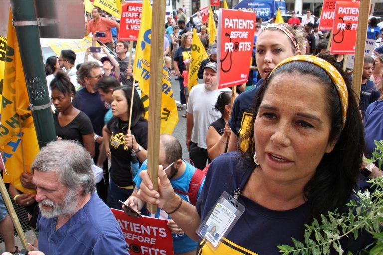 Hahnemann nurse Joelle Leone (right) chants with about 800 protesters outside Hahnemann Hospital to demand that the facility remain open. (Emma Lee/WHYY)